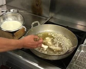 Японский повар мешает жарящиеся в масле продукты руками